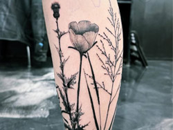 A Fine Line Flowers using thin, precise lines to create delicate and intricate designs on a client's leg by tattoo artist Travis Dale